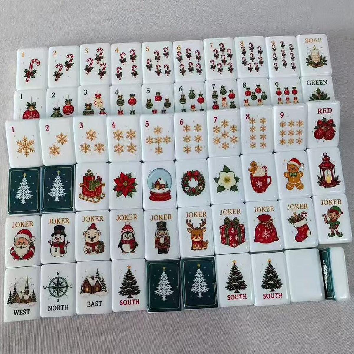 Candy Cane Christmas American Mahjong set laid out: candy cane, ornament and snowflake suits, Soap, Green and Red dragons, Flowers, Jokers, Winds and dark green tile backs